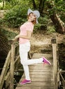 Young cauciasian woman with sunhat posing on the wooden bridge