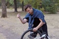 Young causacian man with screwdriver tries to damage the bicycle wire at the abandoned park. Vandal actions. Royalty Free Stock Photo