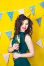 Young celebrating woman green dress, holding a glass of champagne. Royalty Free Stock Photo