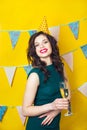 Young celebrating woman green dress, holding a glass of champagne. Royalty Free Stock Photo