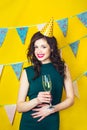 Young celebrating woman green dress, holding a glass of champagne.