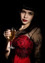 Young celebrating woman in a red dress holding a glass of champagne Royalty Free Stock Photo