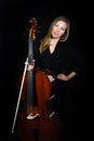 Young cellist standing on black background Royalty Free Stock Photo