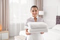Young chambermaid with clean towels Royalty Free Stock Photo