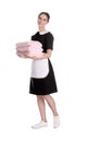 Young chambermaid holding stack of fresh towels on background