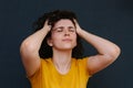 Young charismatic caucasian woman showing pain on her face on the grey background.