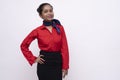 Young charming air hostess in red dress with blue collar posing in front of the camera with white background and copy space Royalty Free Stock Photo