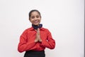 Young charming air hostess wearing red uniform greeting with namesty