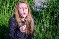 Young charming beautiful girl with long hair Europeans in a meadow with grass and flowers, plucked a flower dandelion and blowing Royalty Free Stock Photo