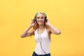 Young charming blond woman with happy exited emotional face looking at camera, isolated over yellow background Royalty Free Stock Photo