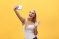 Young charming blond woman with happy exited emotional face looking at camera, over yellow background Royalty Free Stock Photo