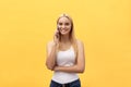 Young charming blond woman with happy exited emotional face looking at camera, over yellow background Royalty Free Stock Photo