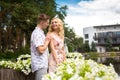 Young charming blonde girl is flirting and with a guy in the garden. Lovestory of a couple in love Royalty Free Stock Photo