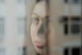 Young charming brunette girl behind a glass window Royalty Free Stock Photo