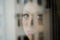 Young charming brunette girl behind a glass window Royalty Free Stock Photo