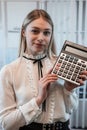 Young charming caucasian woman in suit hold calculator in business cetner