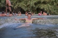 ROMA, ITALY - JULY 2019: Young charming girl bathes in the healing thermal mineral springs in the resort of Saturnia Italy