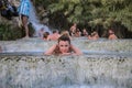 ROMA, ITALY - JULY 2019: Young charming girl bathes in the healing thermal mineral springs in the resort of Saturnia Italy