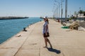 ROMA, ITALY - JULY 2017: Young charming girl in a cap with the coat of arms of Malta and glasses, strolls along the embankment in