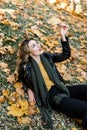 Young charming girl with curled long blonde hair and red lipstick on her lips is enjoying autumn Royalty Free Stock Photo