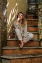 Young charming girl sitting on the old antique stone steps Royalty Free Stock Photo