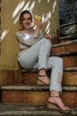 Young charming girl sitting on the old antique stone steps Royalty Free Stock Photo