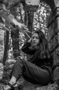 Young charming girl the teenager with long hair sitting on the sad ruins of an ancient stone castle window in Striysky Park in Lvi Royalty Free Stock Photo