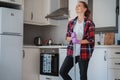 Young charming happy smiling girl woman stands on the background of the kitchen with a mop in her hands. House Hygiene and