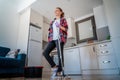 Young charming happy smiling girl woman stands on the background of the kitchen with a mop in her hands. House Hygiene and