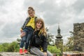 Young charming mother and daughter on the ruins of an old fortress against the background of church domes