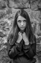 Young charming teenager girl with long dark hair standing near the ruins of the ancient castle fortress with a sad expression on Royalty Free Stock Photo