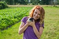 Young charming woman farmer with long hair in a shirt, in a village in his garden walks holding the hands of two young fluffy Royalty Free Stock Photo