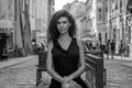 Young charming woman with long curly hair, strolling among the old town of Lviv architecture in black dress Royalty Free Stock Photo