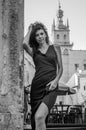 Young charming woman with long curly hair, strolling among the old town of Lviv architecture in black dress Royalty Free Stock Photo