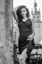 Young charming woman with long curly hair, strolling among the old town of Lviv architecture in black dress Royalty Free Stock Photo