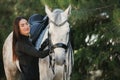 Young charming woman walking with white horse in summer warm day at country estate. Lifestyle mood. Concept of nature Royalty Free Stock Photo