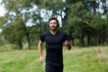 Young cheerful active guy sporty walking with headphones mobile phone enjoying listening to music, jogging outdoors on urban city Royalty Free Stock Photo