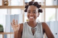 Young cheerful African american businesswoman waving her hand while sitting at a table in an office. Joyful black female Royalty Free Stock Photo