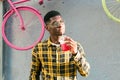 Young cheerful african american male on city having fun and holding cocktail. Man on summer holiday. Leisure lifestyle Royalty Free Stock Photo