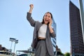 Young cheerful Asian businesswoman talking on cellphone laughing on city street. Royalty Free Stock Photo