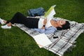 Young cheerful asian female student reading book, lying on the g Royalty Free Stock Photo