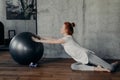 Young cheerful athletic woman with red hair exercising indoors with fitball Royalty Free Stock Photo