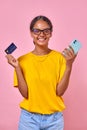 Young cheerful attractive Indian woman teen holding phone and credit card Royalty Free Stock Photo