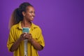 Young cheerful beautiful African American woman with phone in hand and smiling Royalty Free Stock Photo