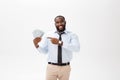 Young cheerful black businessman holding and pointing at money isolated on white