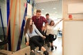 Young cheerful business people in smart casual wear having fun while racing on office chairs and smiling. Royalty Free Stock Photo