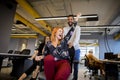 Young business people in smart casual wear having fun while racing on office chairs and smiling Royalty Free Stock Photo