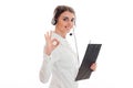 Young cheerful business woman in uniform with headphones and microphone looking at the camera and showing OK isolated on Royalty Free Stock Photo