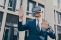 Young businessman with beard dressed in blue formal suit trying out VR glasses outdoors Royalty Free Stock Photo