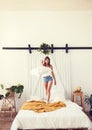 Young cheerful caucasian woman jumping on bed Royalty Free Stock Photo